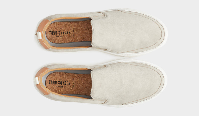 A black sneaker is shown with both leather and suede craftmanship.