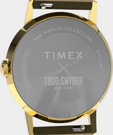 Gold watch with Timex and Todd Snyder branding on a gray background