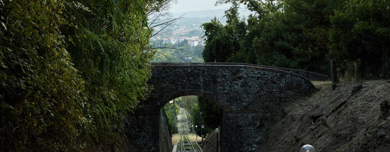 A landscape shows a charming Italian town in the background, with a stone bride in the foreground.
