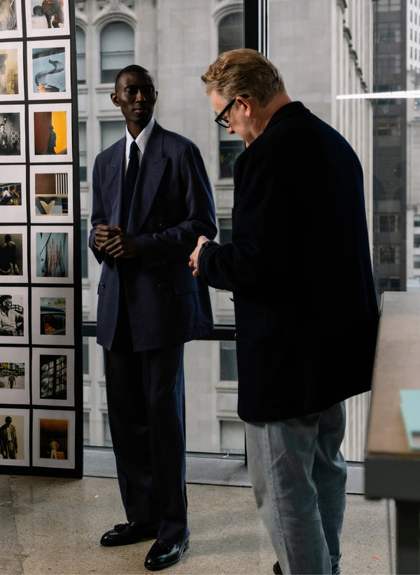 Todd Snyder is shown interacting with a man in a well tailored suit.